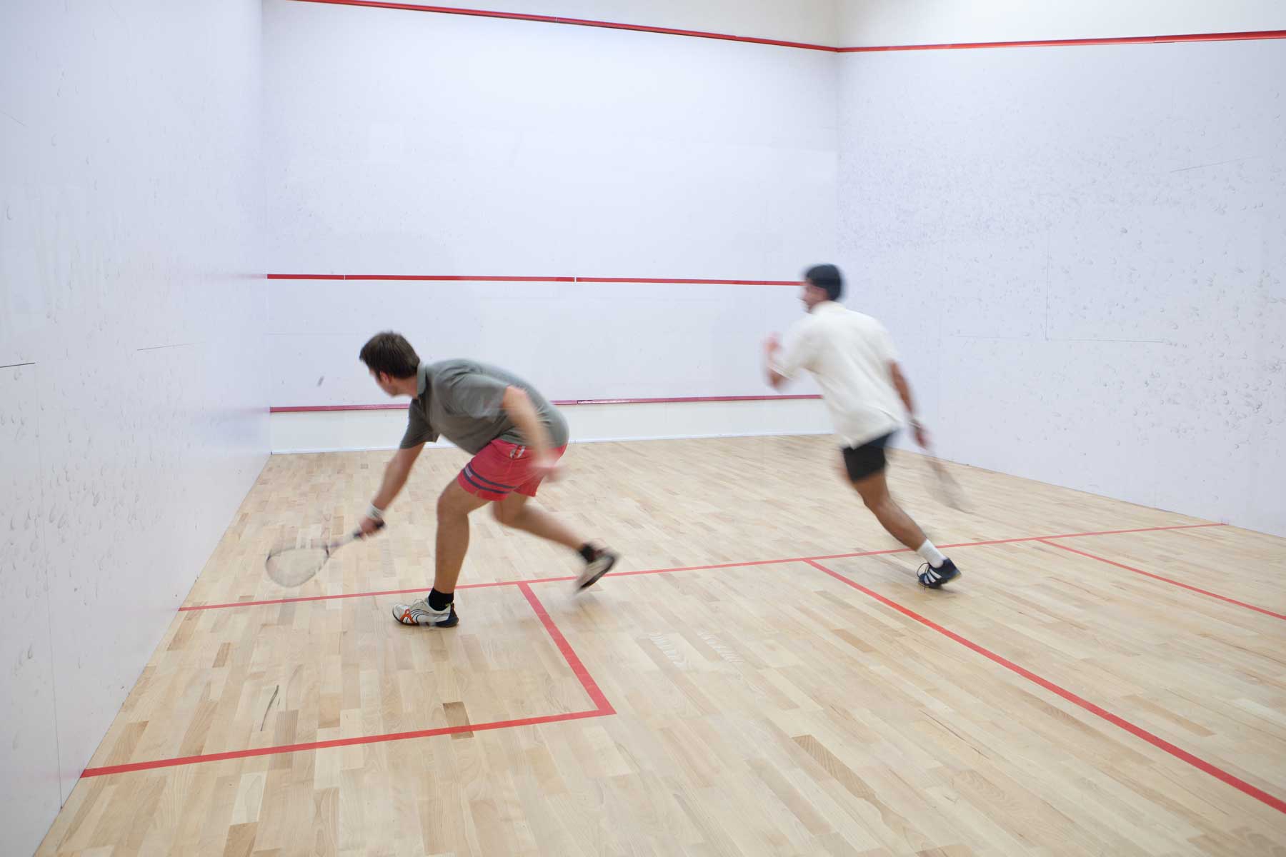 Two players competing on a squash court